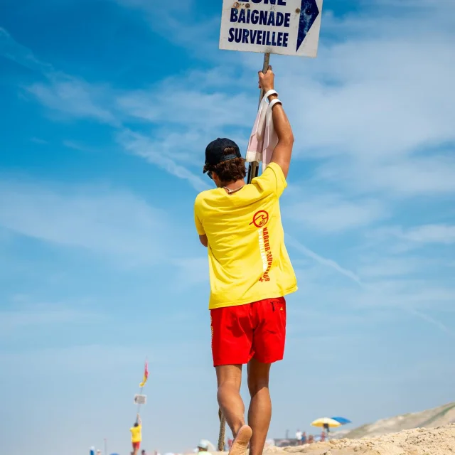 socorrista con señal de zona de baño